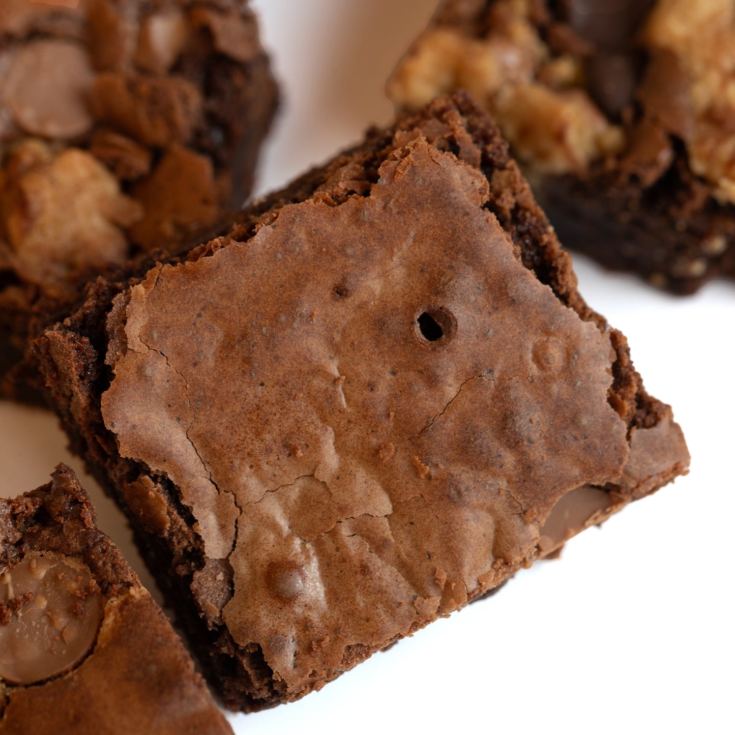 Close-up of a chocolate brownie with nuts on a white background